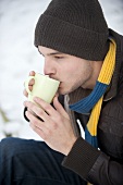 Junger Mann trinkt Kakao