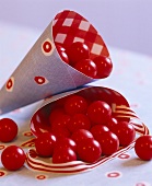 Papierkegel sind gefüllt mit leuchtend roten Bonbons zu Weihnachten