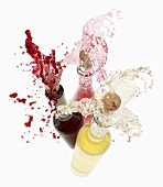 Wein spritzt aus den Flaschen (Rotwein, Rosewein, Weisswein)
