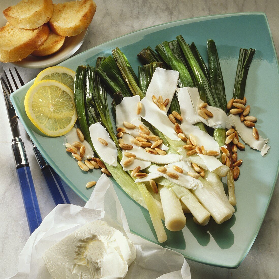 Steamed leeks with sheep's cheese and pine nuts
