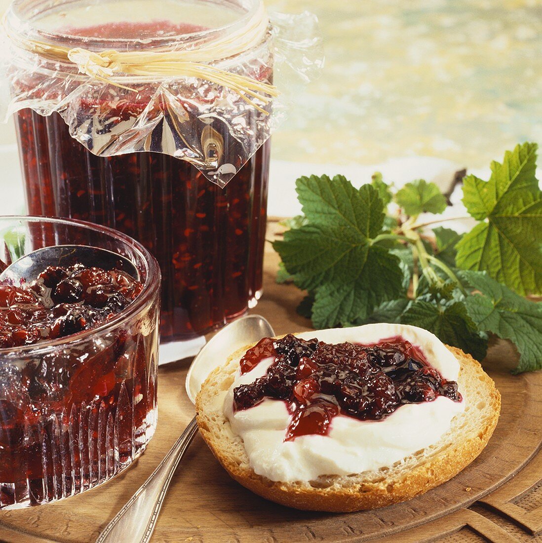 Red berry jam in jar and on bread roll