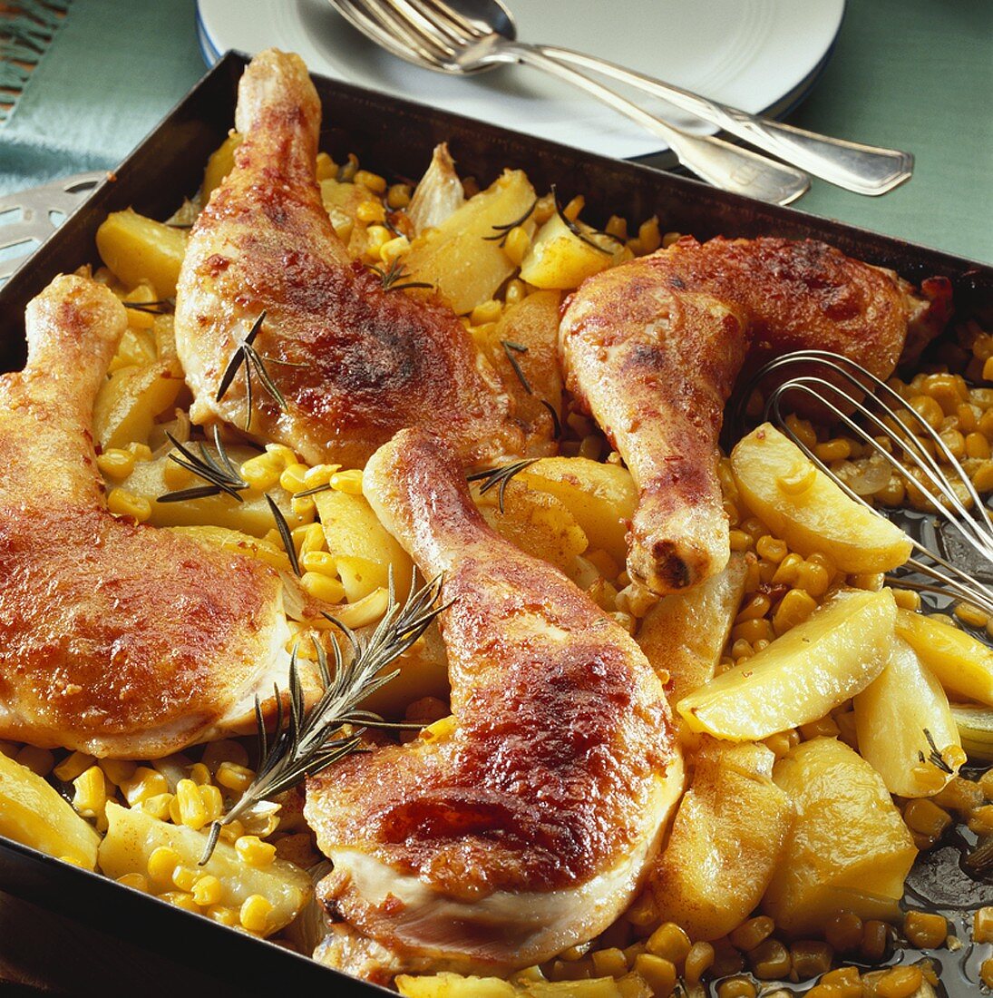 Chicken legs on potatoes and sweetcorn