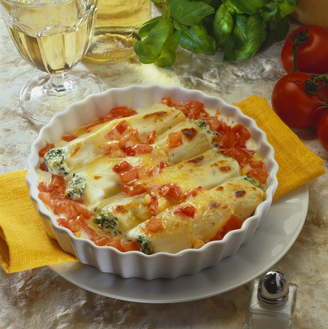 Filled cannelloni with tomatoes in a gratin dish