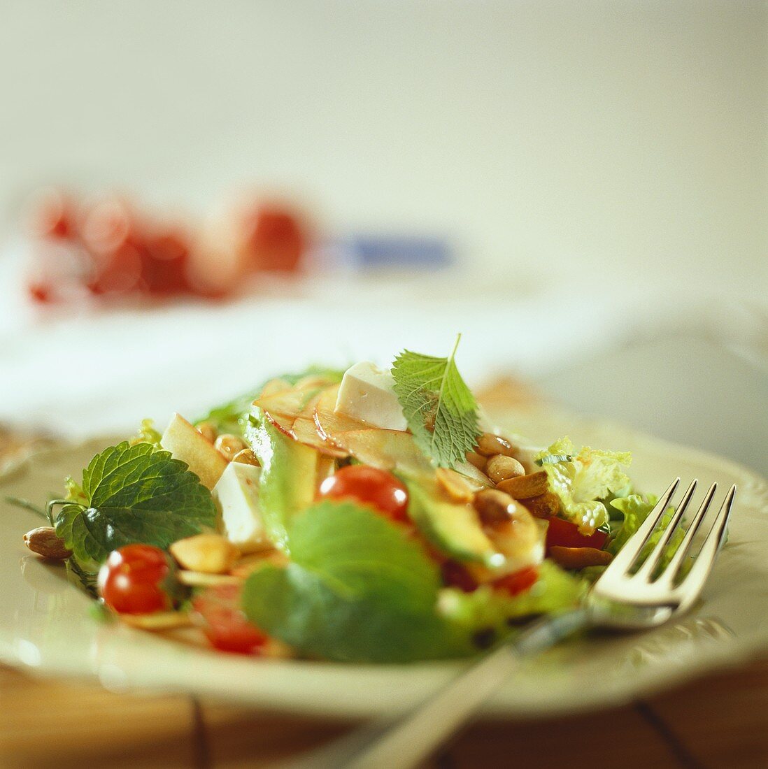 Blattsalat mit Kirschtomaten, Äpfeln, Avocado und Nüssen