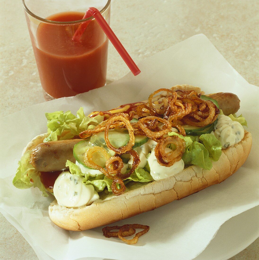 Hot dog mit Bratwurst, Salat, Gurken, Remoulade & Zwiebeln