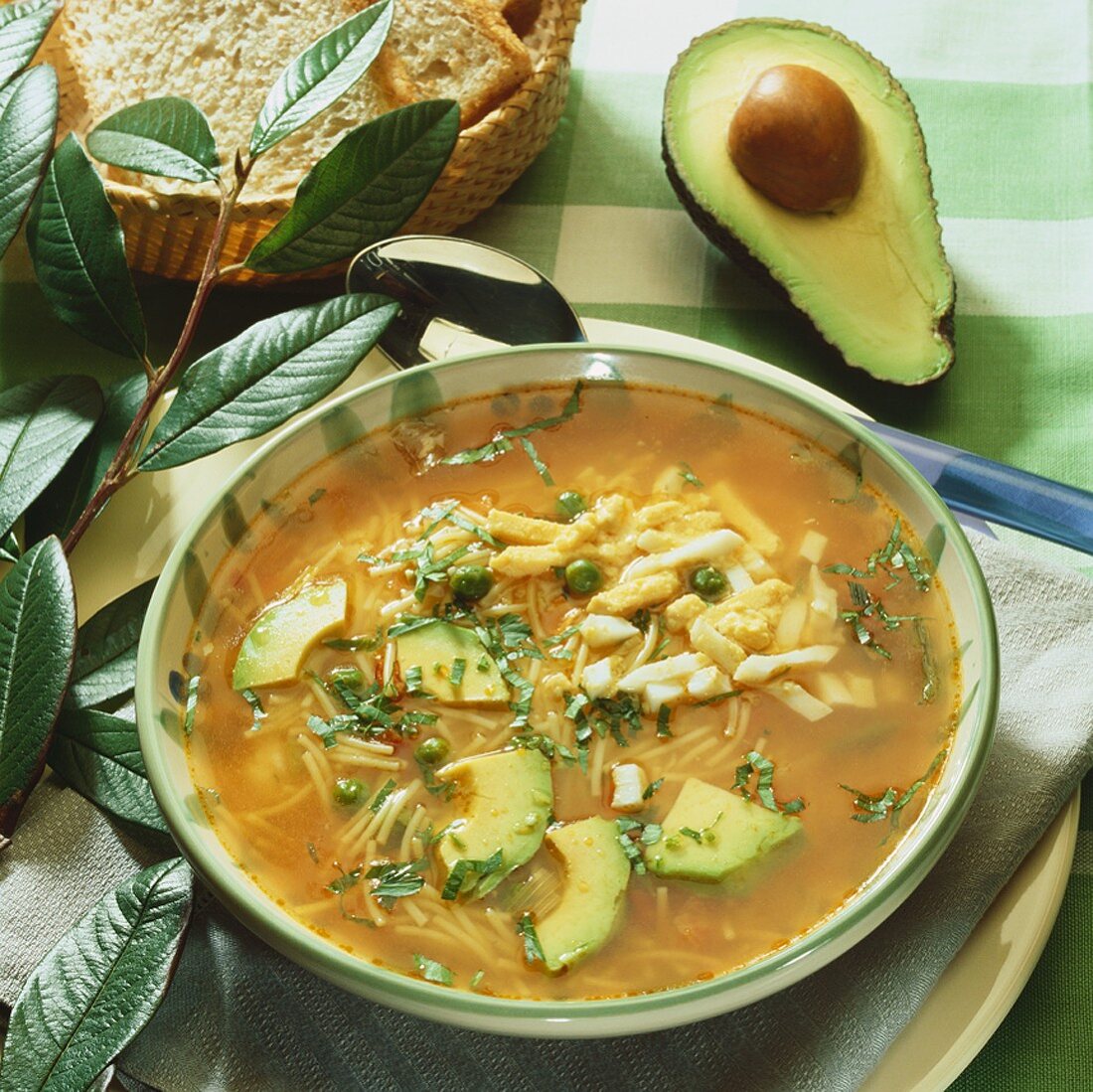 Clear tomato consommé with noodles, egg and avocado