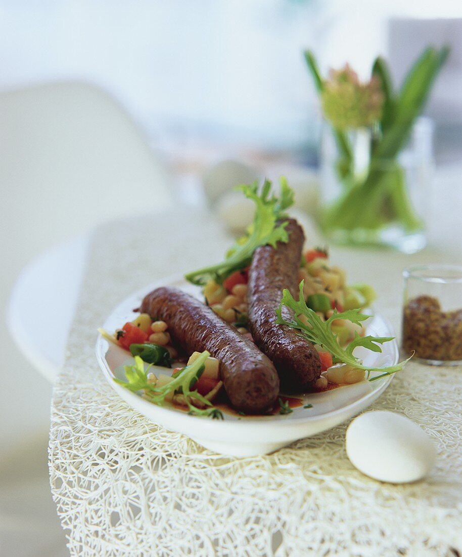 Home-made lamb sausages on warm bean salad