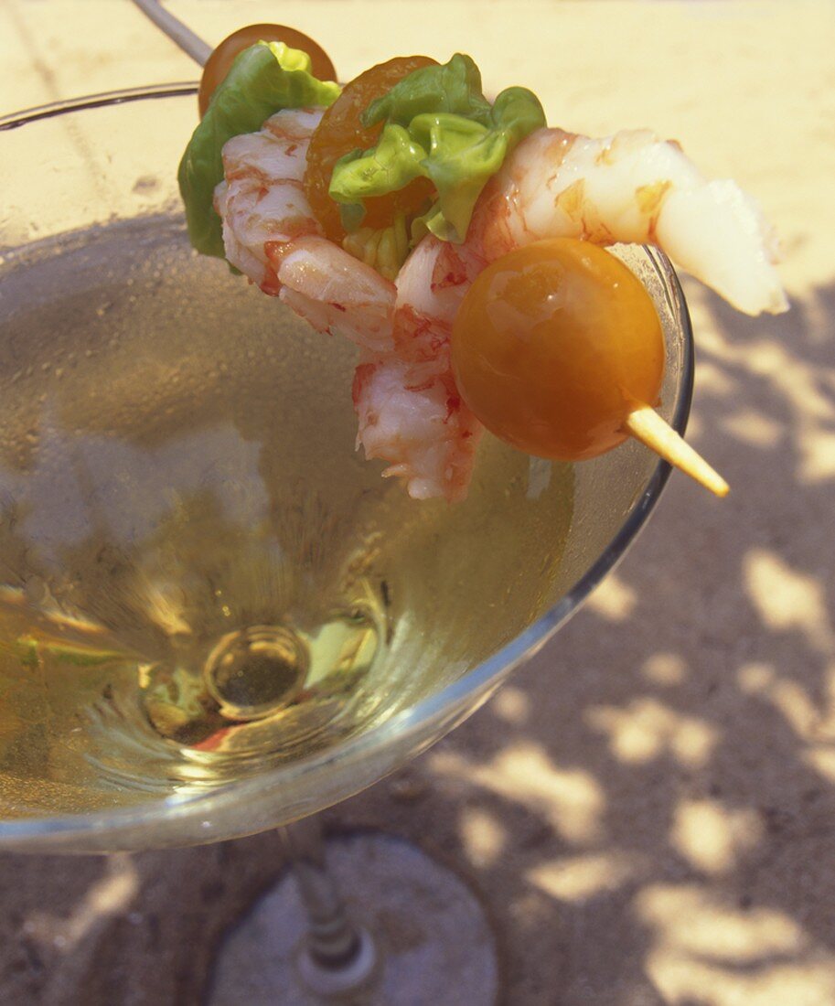 Garnelenspiess auf einem Glas Cava (spanischer Sekt)