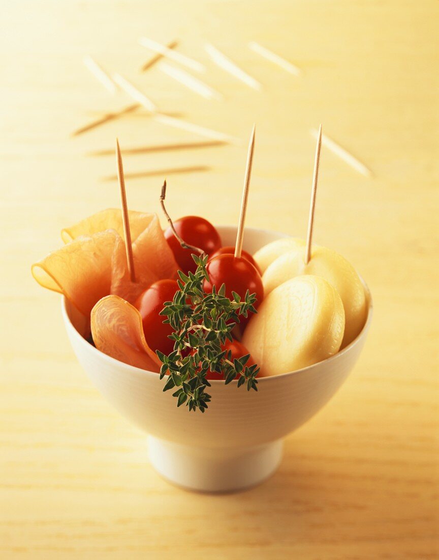 Bowl of baby Goudas, tomatoes, ham and thyme