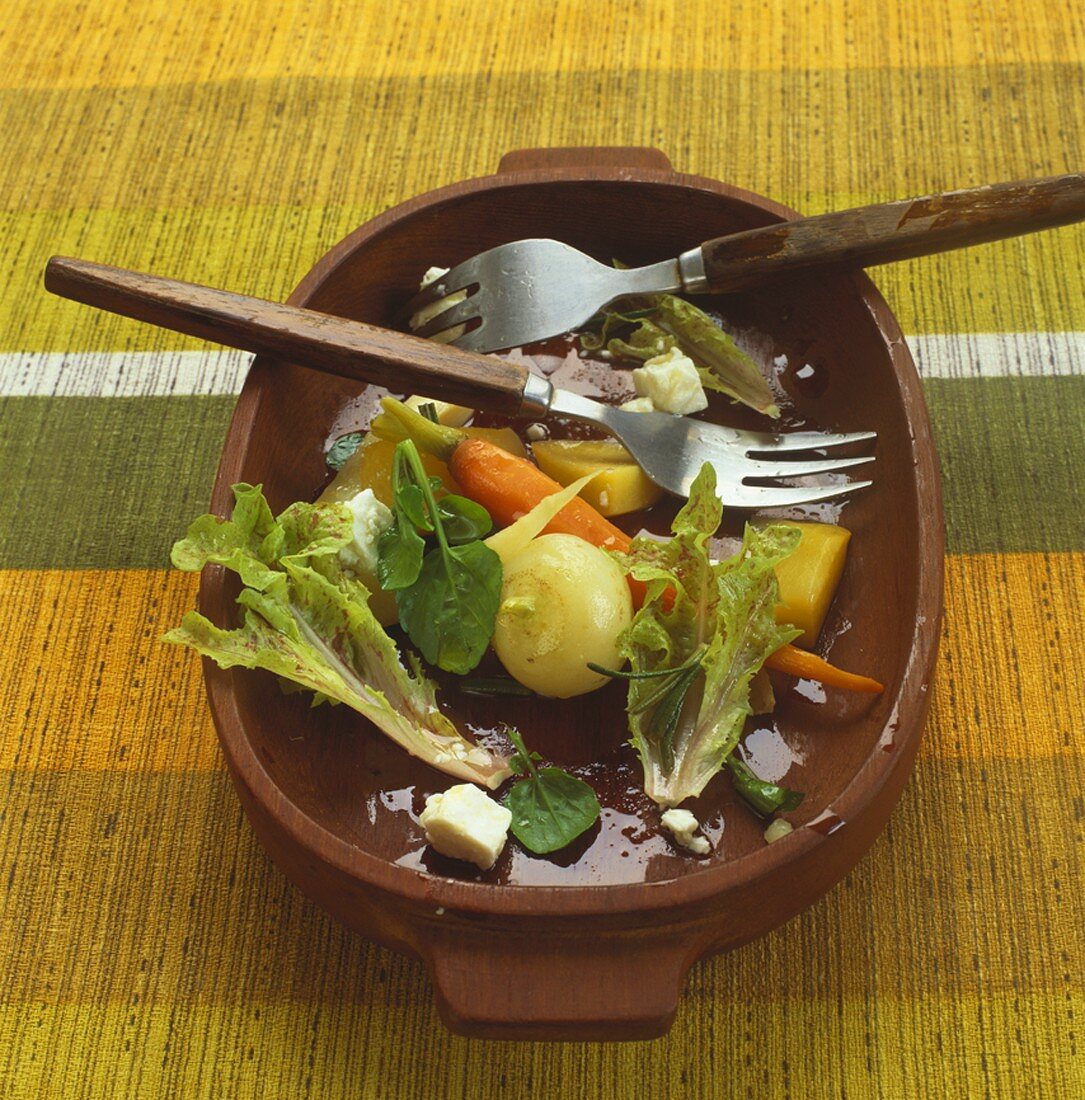 Halb gegessener Wurzelgemüse-Salat in Holzschüssel
