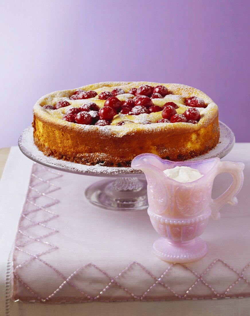 Ganzer Kirschkäsekuchen auf Glas-Etagere