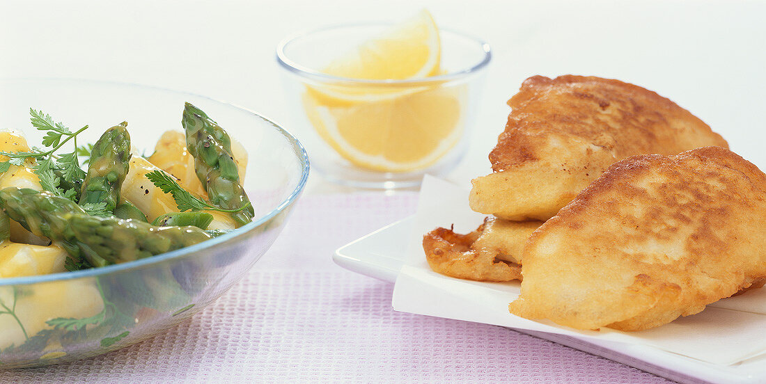 Deep-fried fish in batter with asparagus and herb salad