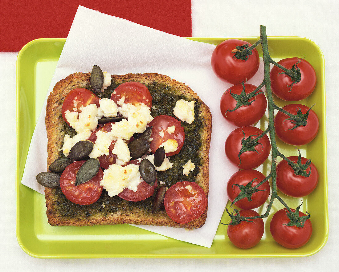 Cherry tomatoes, pesto and feta on toast