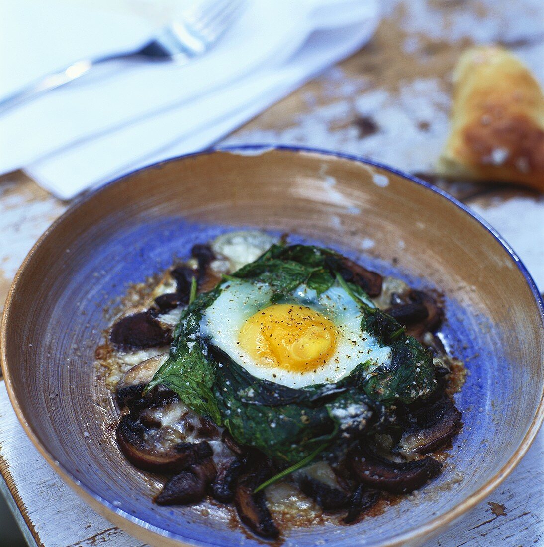 Gebackenes Ei mit Spinat, Champignons und Cheddar-Käse