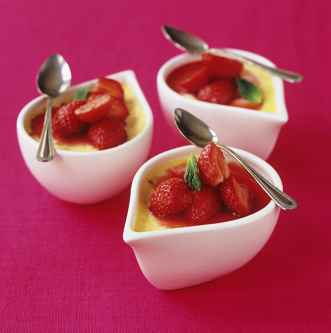 Crème Caramel mit Erdbeeren in drei Schälchen