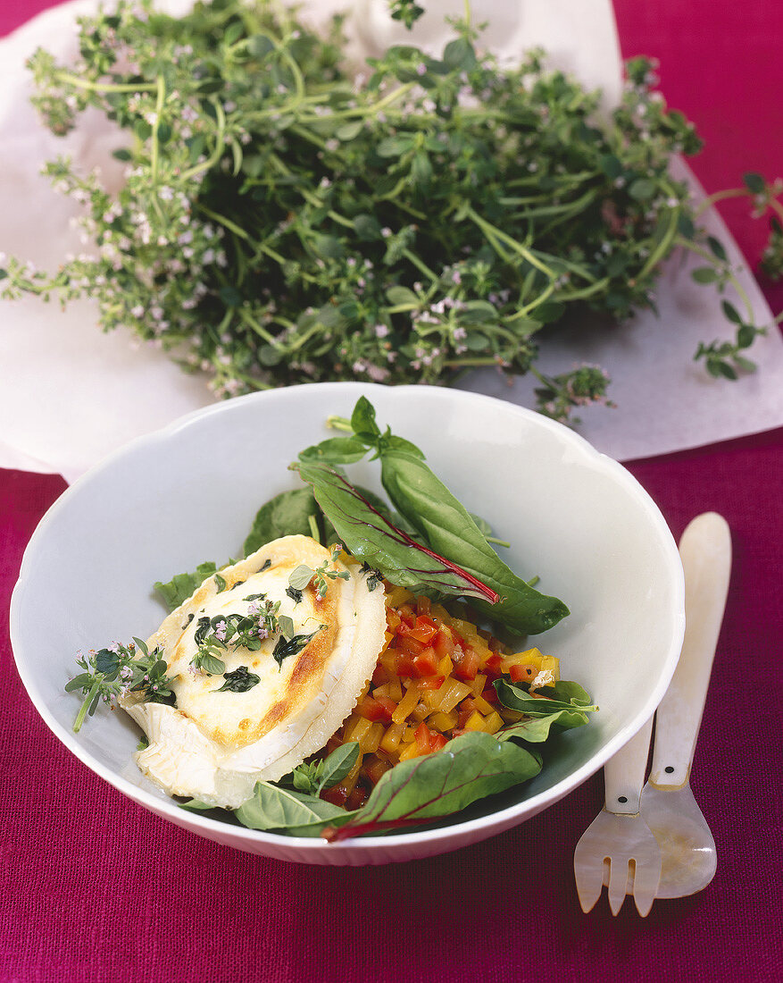 Toasted goat's cheese with thyme flowers on pepper salad