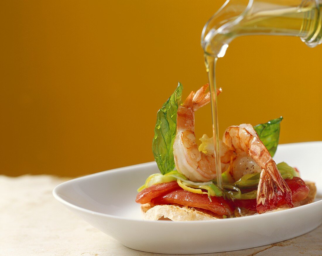 Drizzling prawns on ciabatta with olive oil