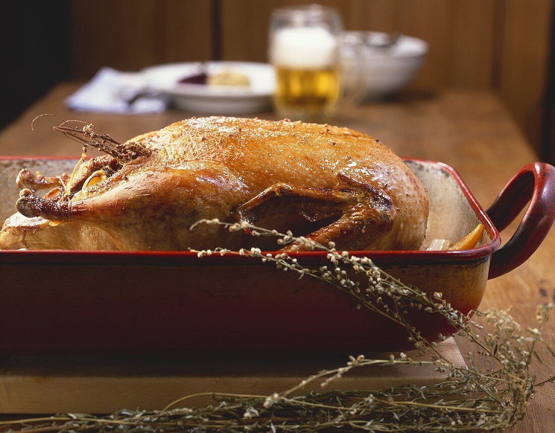 A whole roast duck in a roasting dish