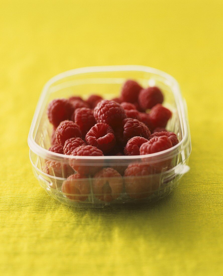 Fresh raspberries in a plastic container