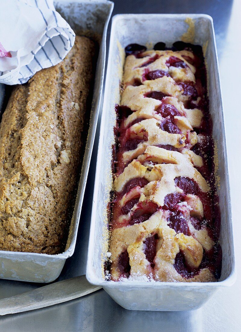 Banana cake and plum cake in two loaf tins