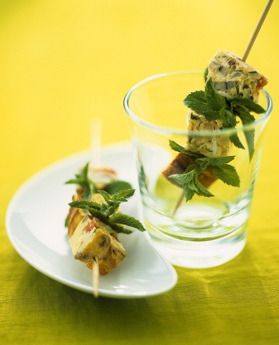 Cubes of vegetable omelette and herbs on skewers
