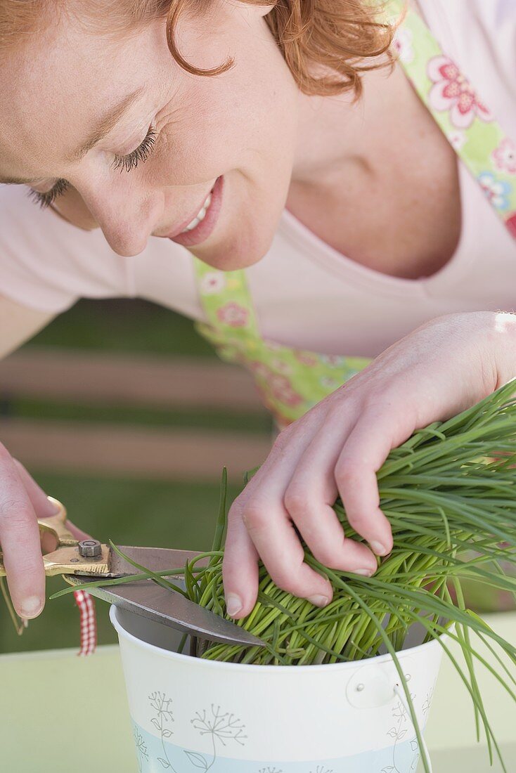 Young woman cutting chives