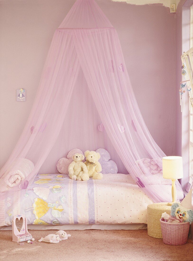 A child's room in pink with canopy over the bed