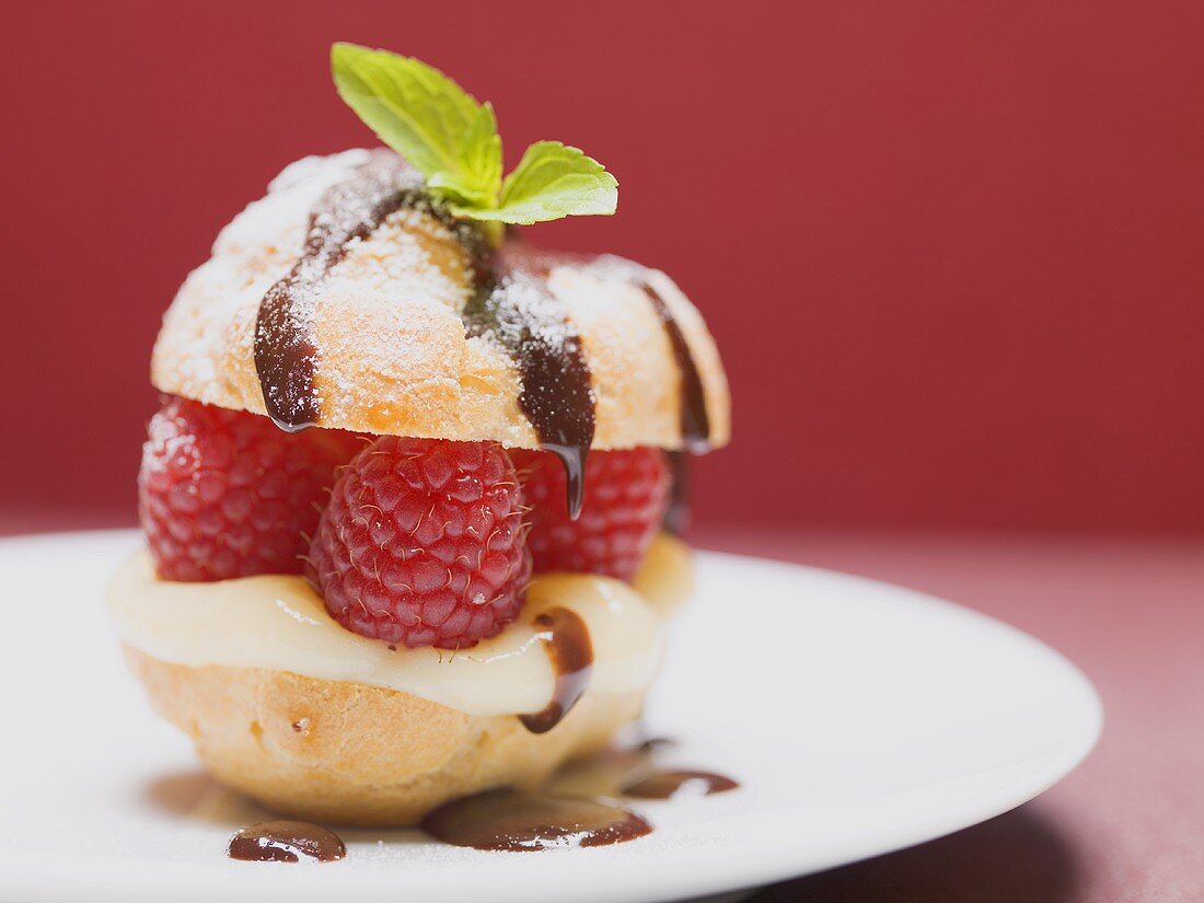 Ein kleiner Windbeutel mit Himbeeren und Vanillecreme