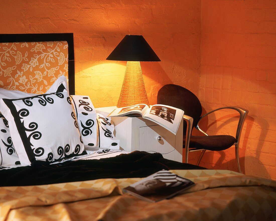 Warm light from lit bedside table in orange bedroom