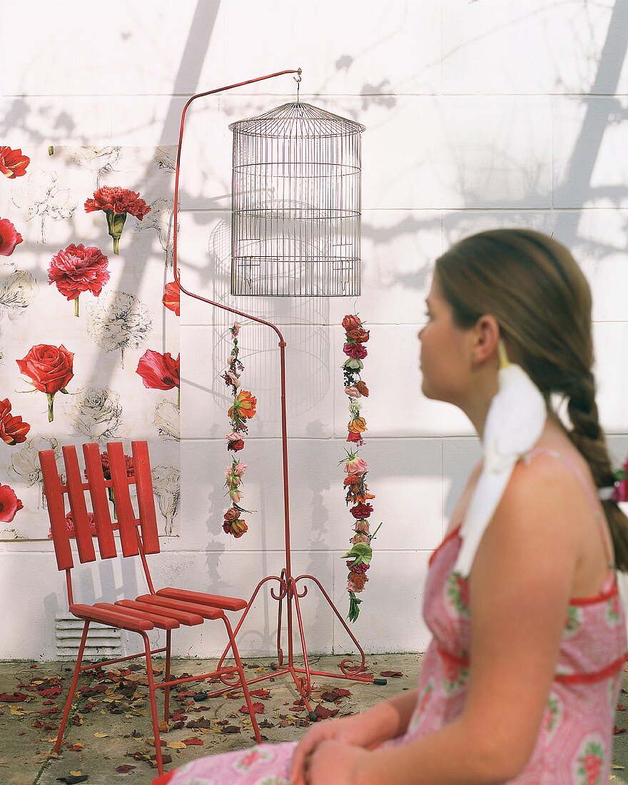 Girl in front of chair and birdcage