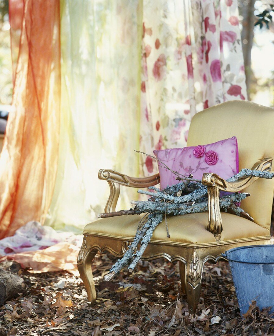 Golden chair in garden amongst leaf litter