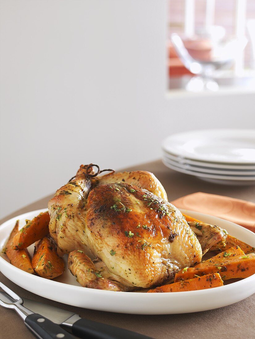 A roast chicken with pumpkin on a serving platter