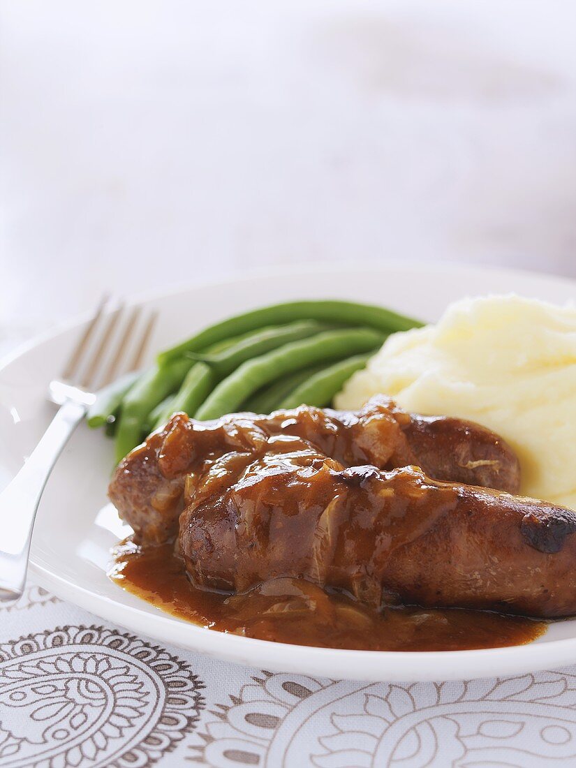 Bratwürste mit Zwiebelsauce, Kartoffelbrei und grünen Bohnen