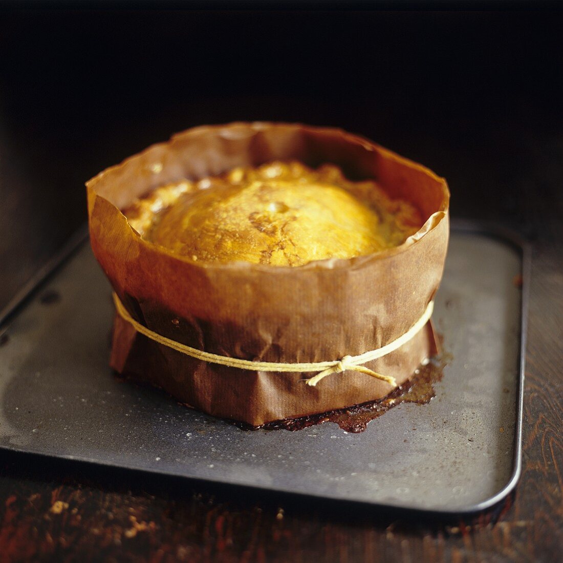 Schweinefleischpie auf Backblech mit Papier umwickelt