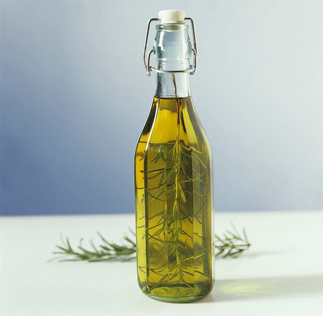 A bottle of olive oil with rosemary