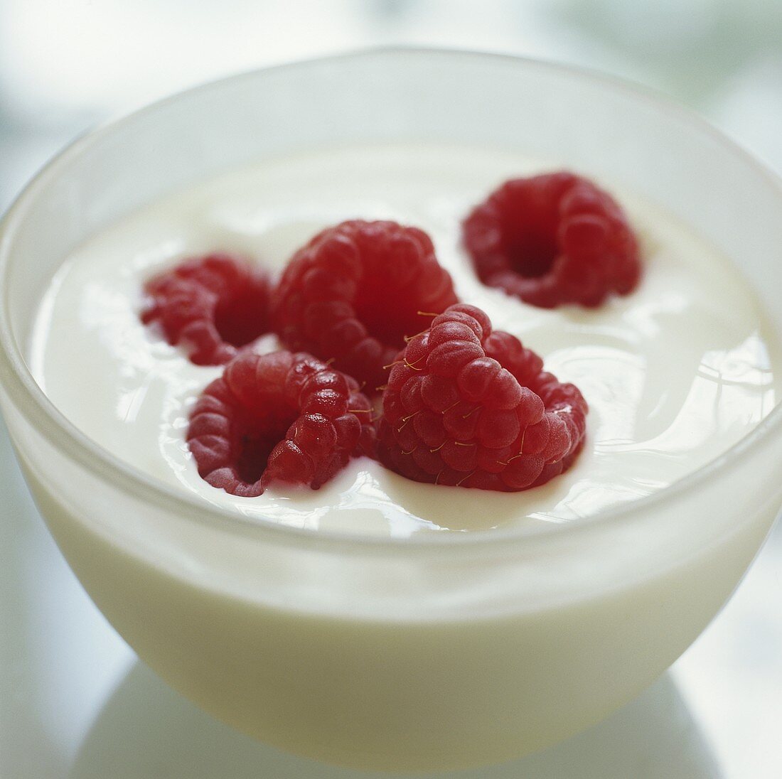 A bowl of yoghurt with fresh raspberries