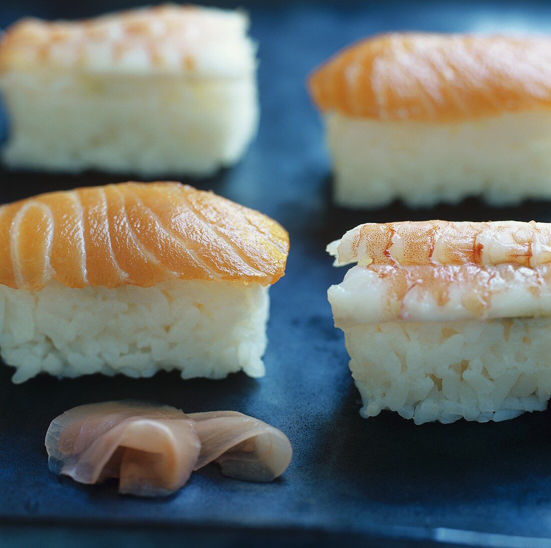 Four nigiri sushi with salmon and prawns