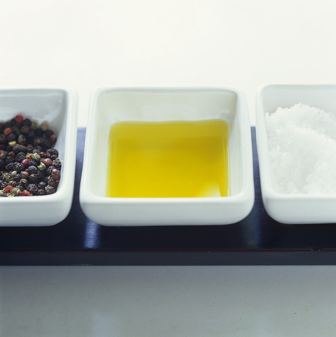 Peppercorns, oil and sea salt in three dishes