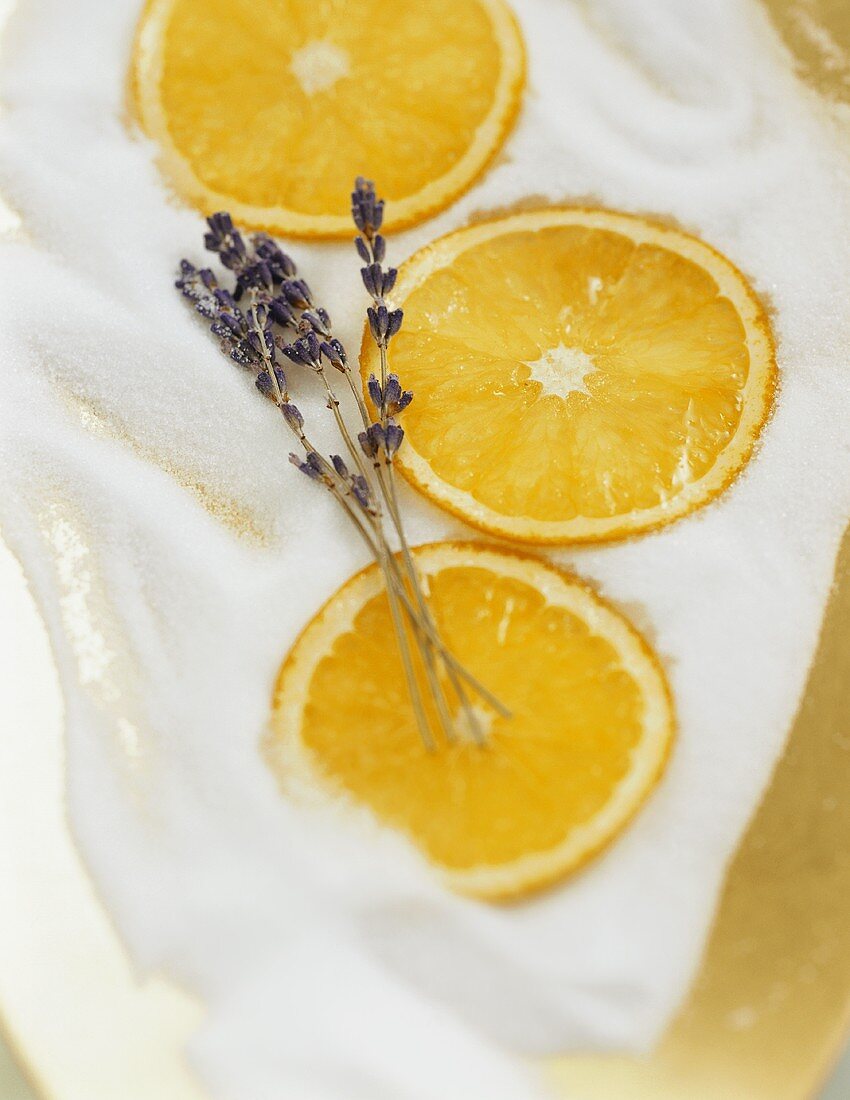Orangenscheiben und Lavendelblüten auf Zucker