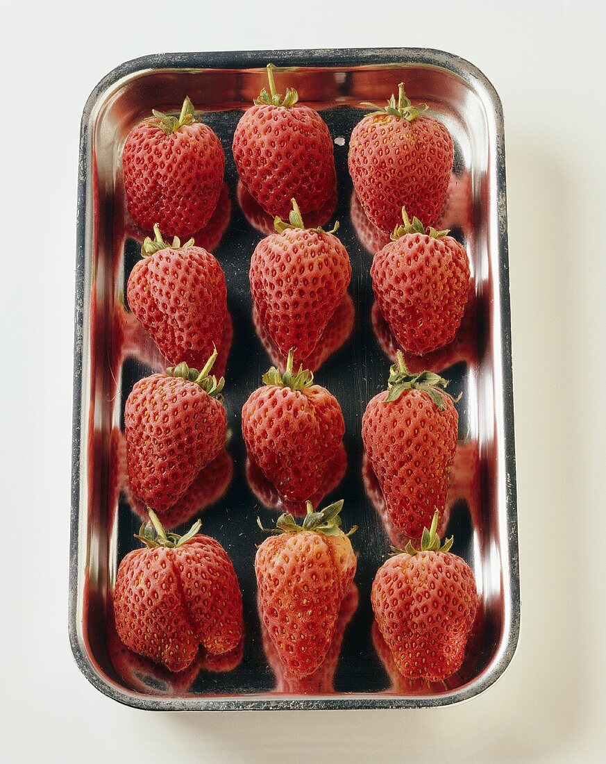 Twelve strawberries in a dish