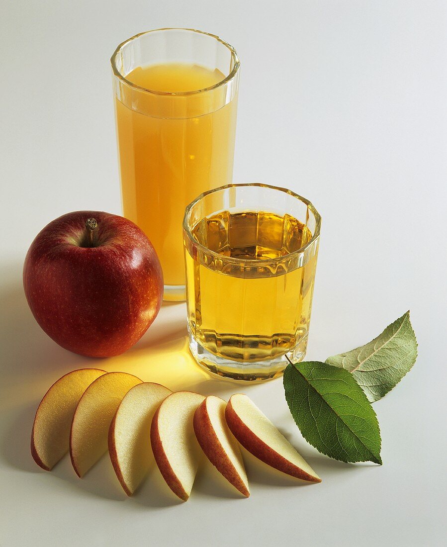 Two glasses of apple juice and apples
