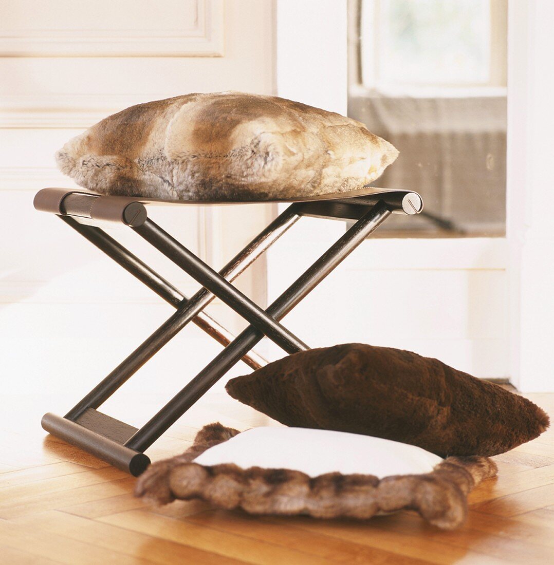 Fur cushions on & in front of folding stool