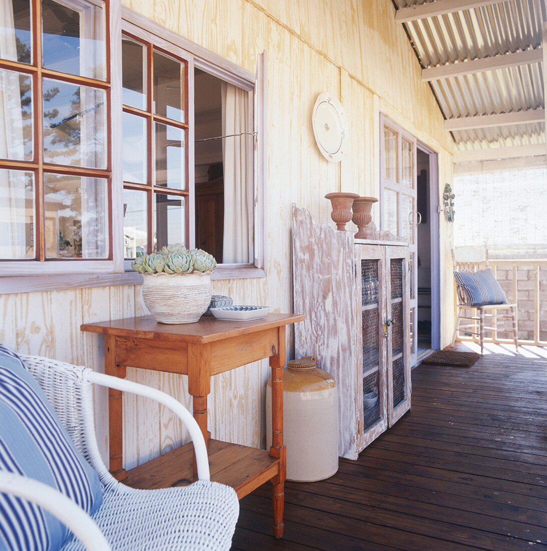 Vintagemöbel auf einer Holzveranda mit Wellblechüberdachung