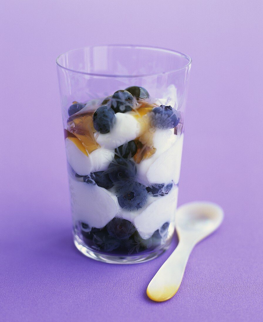 Quark with fresh blueberries and honey in a glass