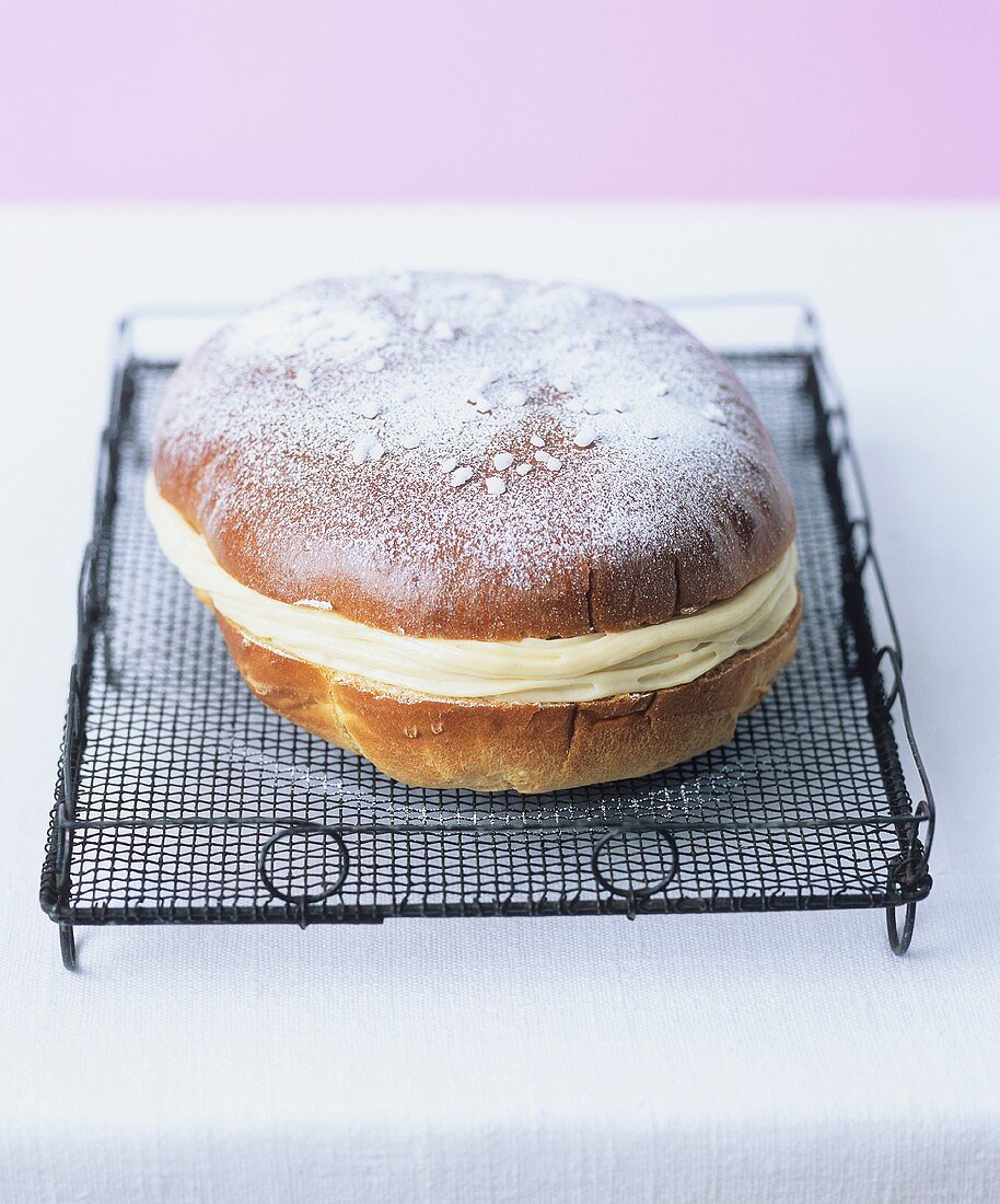 Yeast cake filled with vanilla cream on a cake rack