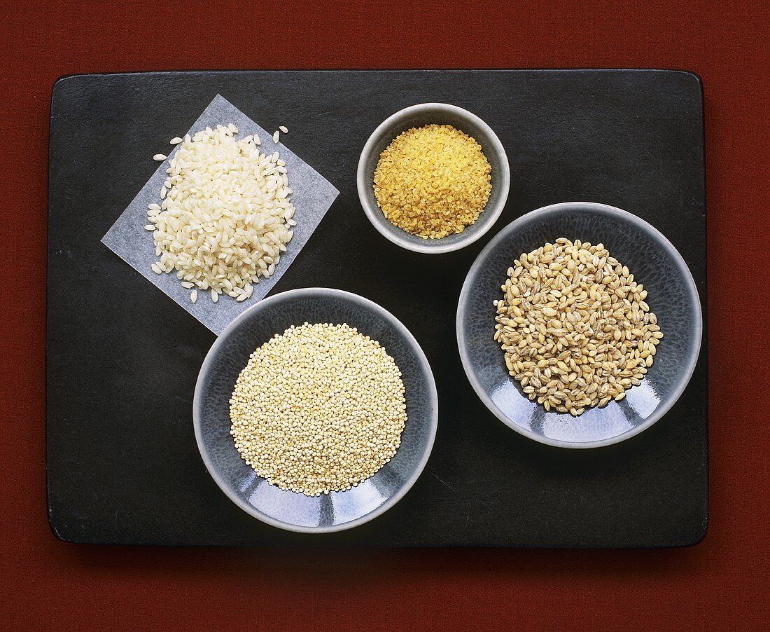 Pearl barley, quinoa, risotto rice and bulgur on plates