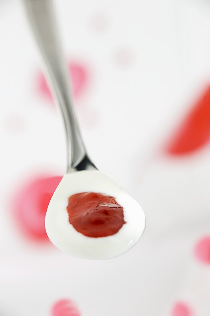 A spoonful of yoghurt with strawberry jam
