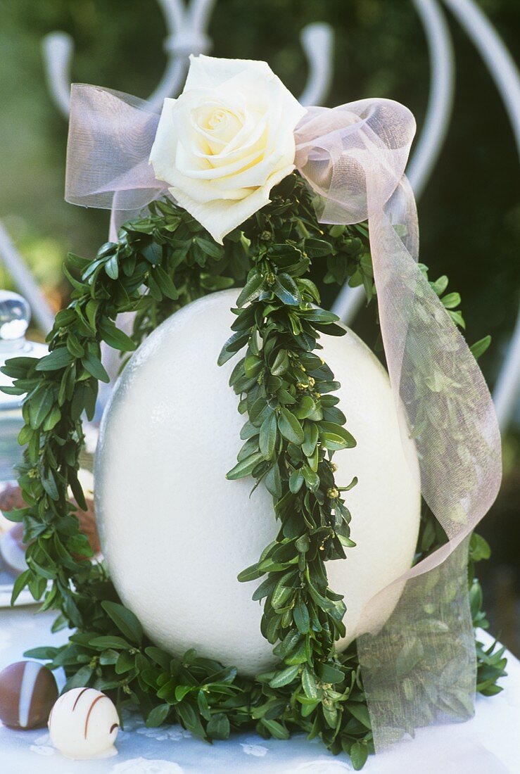 Easter decoration: ostrich egg with box, rose and bow