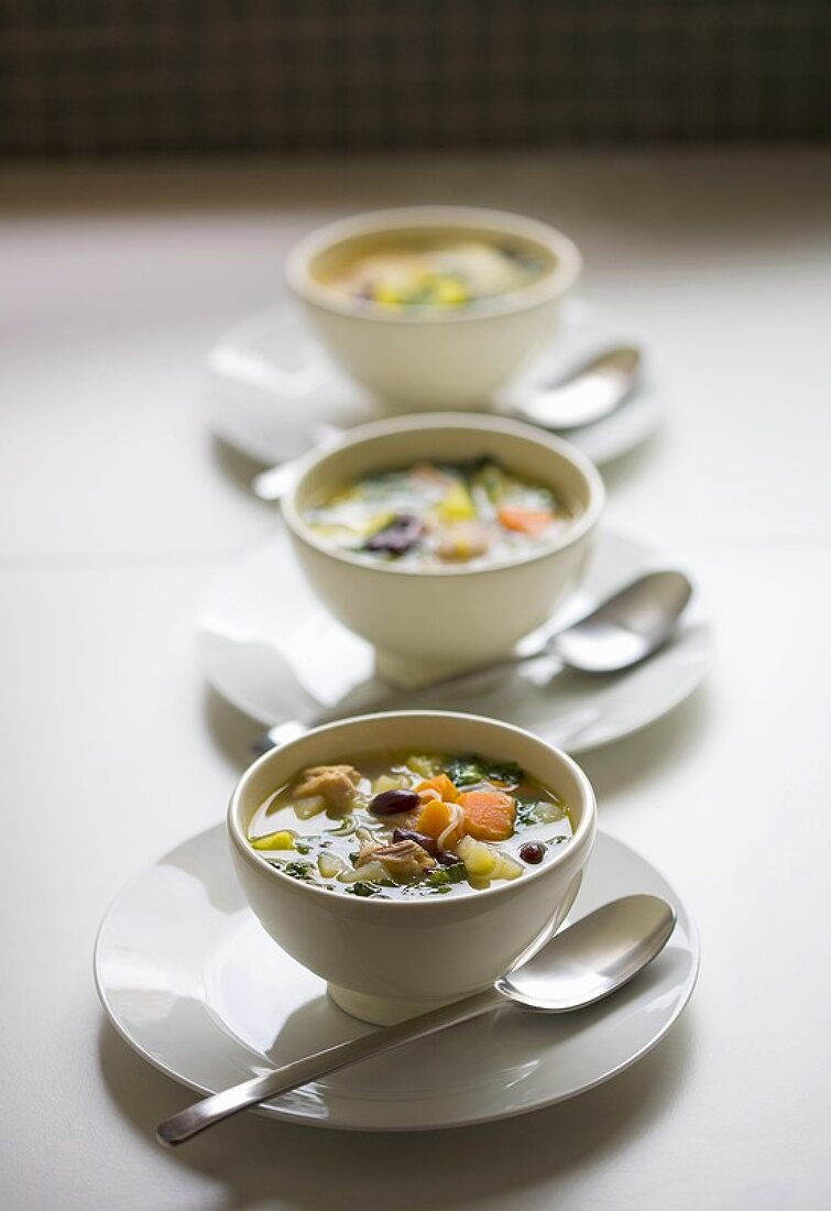 Deftige Suppe mit Gemüse, Nudeln und Fleisch in Suppentassen