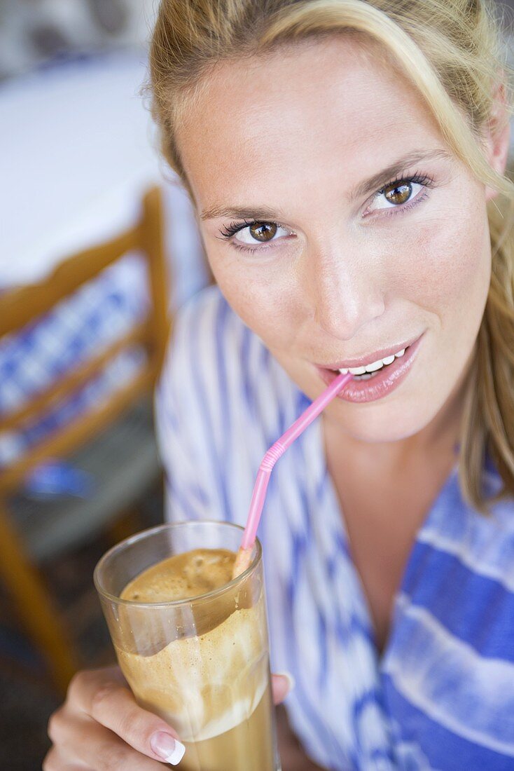 Frau trinkt einen Eiskaffee